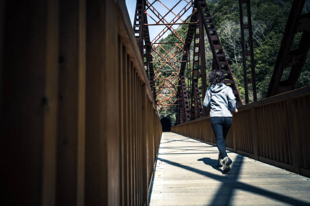 istock Asian lady running on the iron bridge 1016909746