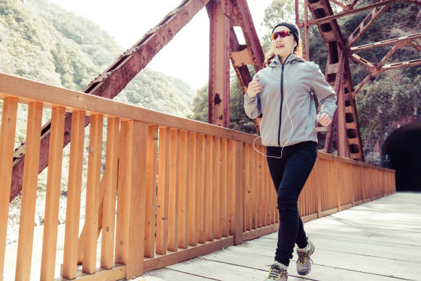 istock Asian lady running on the iron bridge 1016909750