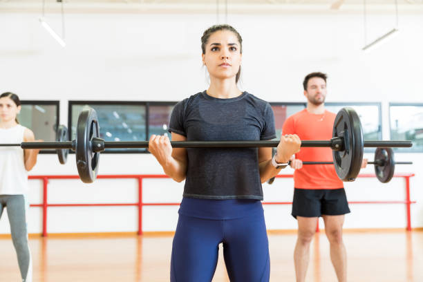istock Female Practicing Weight Training With Friends In Gym 1016948260