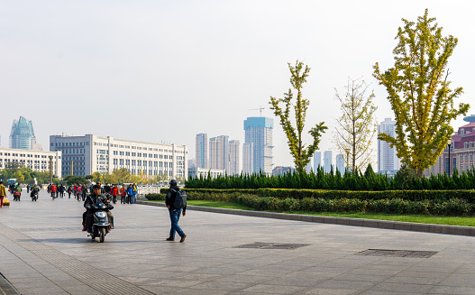 Tianjin, China - Nov 1, 2016: Promenade at the Tianjin Railway Station. Pedestrians and light vehicles frequent the pathway.