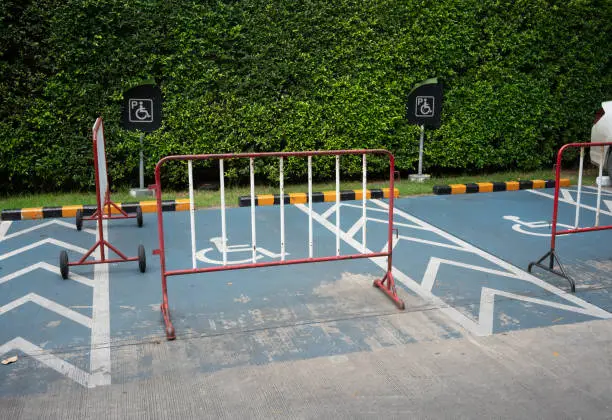 Photo of Red and white steel barrier with wheels for no disability people parking lot