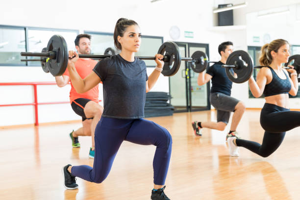 istock Weightlifter Lifting Barbell While Doing Lunges With Friends 1016952360