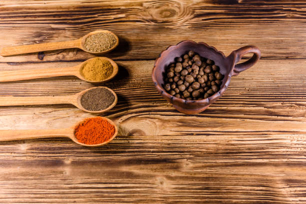 istock Ceramic bowl and spoons with the different spices on wooden table 1016963978