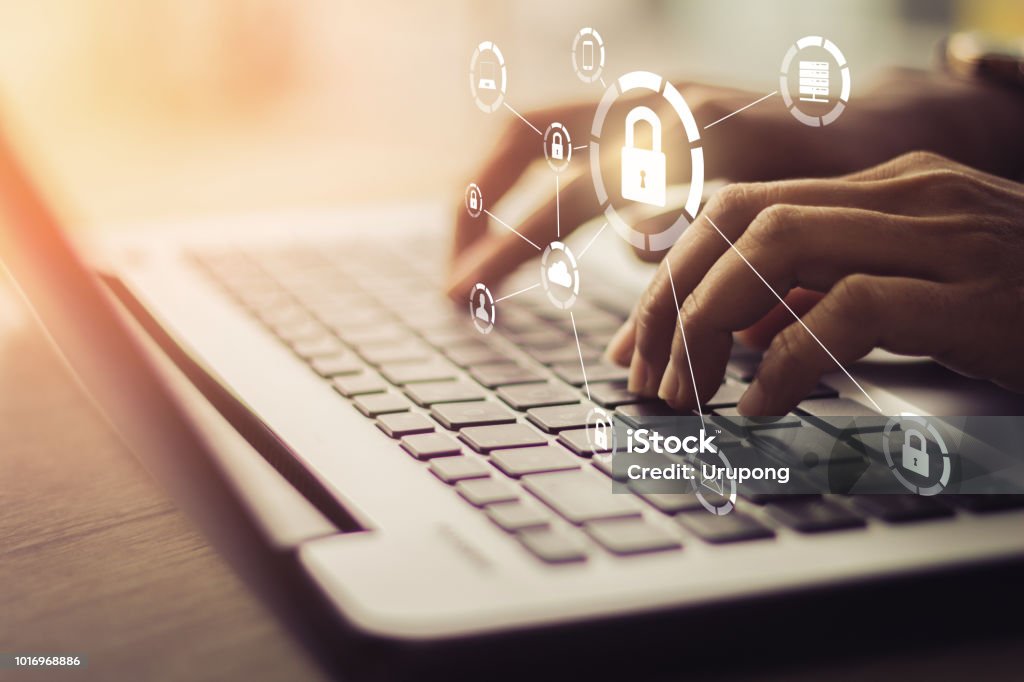 Business, technology, internet and networking concept. Business, technology, internet and networking concept. Young businesswoman working on his laptop in the office, select the icon security on the virtual display. Security Stock Photo