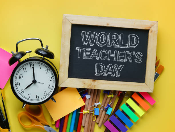World Teacher's Day Text. Alarm Clock, Blackboard and School Stationary on Yellow Background World Teacher's Day Text. Alarm Clock, Blackboard and School Stationary on Yellow Background stapled paper stock pictures, royalty-free photos & images