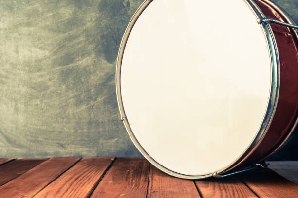 istock Old drum on a red wooden table and wall background. 1016983658
