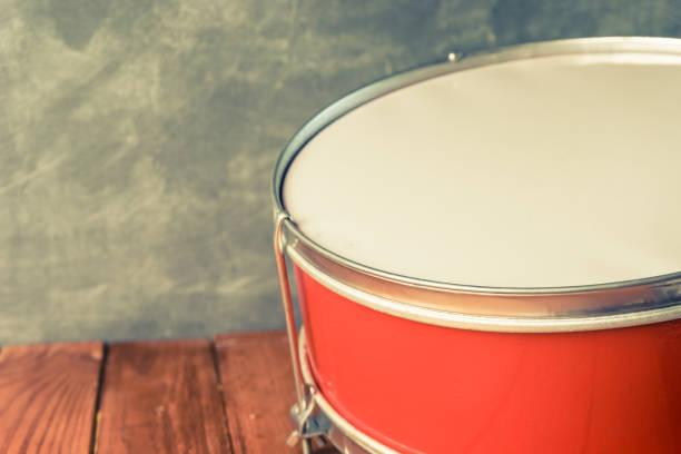 istock Old drum on a red wooden table and wall background. 1016983688