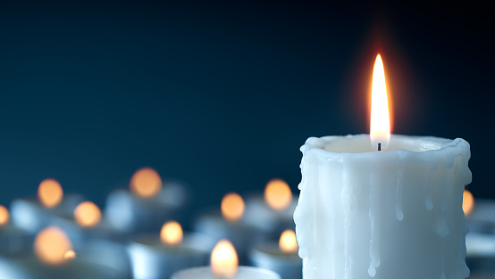 Melting candle on cool blue background