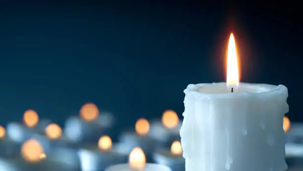 Photo of Melting candle on cool blue background