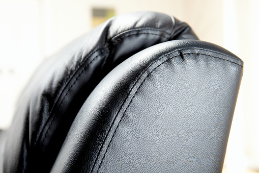 Close up of black leather cushioned sofa in modern living room