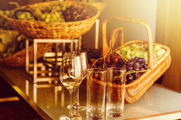 Blue Isabella grapes bunch , Green grapes bunch with the autumn leaves and ripe pomegranate on kitchen table . Glasses with red wine and white wine .