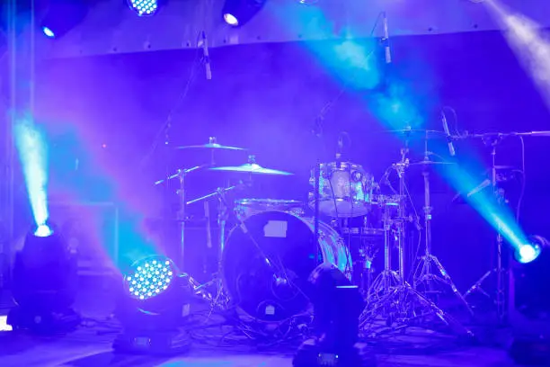 Photo of cymbals set in blue light of searchlights