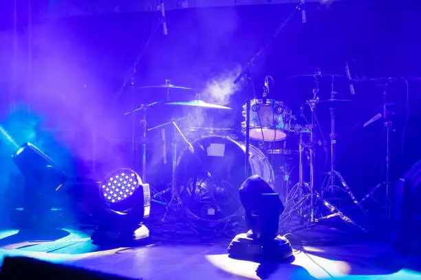 Photo of cymbals set in blue light of searchlights