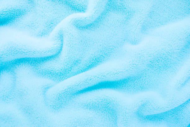 Fluffy Gentle baby blue fabric. Soft pastel textile texture. Folds on the soft fabric. Blue towel terry cloth. Fluffy Gentle baby blue fabric. Soft pastel textile texture. Folds on the soft fabric. Blue towel terry cloth. fleece photos stock pictures, royalty-free photos & images
