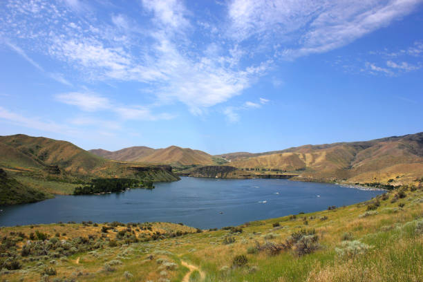 istock Lake with boaters surrounded by mountains and a cloudy sky 1017043566