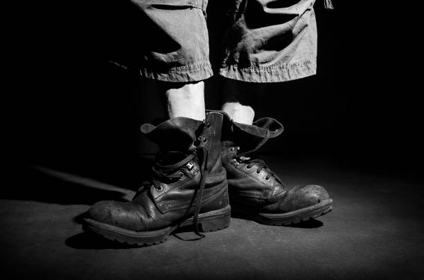 istock Men's legs in old military boots. 1017046108