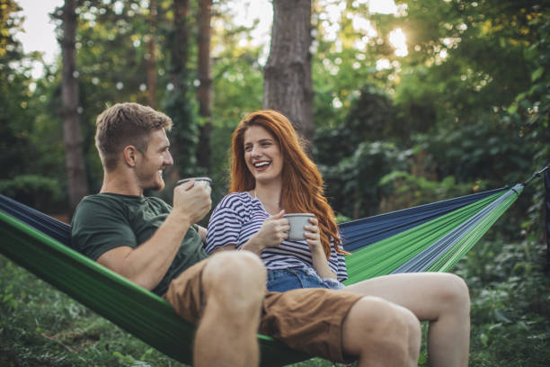 jovem casal desfrutar na rede - summer women hammock nature - fotografias e filmes do acervo