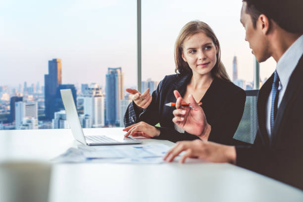 istock Business people discussing while meeting in office, working with laptop 1017054838