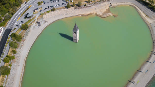 curon, イタリア.ドローン水レージア湖から上がる村の古い鐘タワーの空撮 - great flood ストックフォトと画像