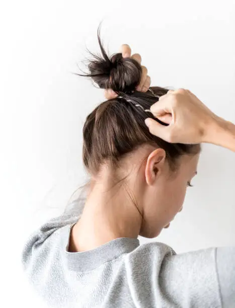 Photo of Woman making hair bun