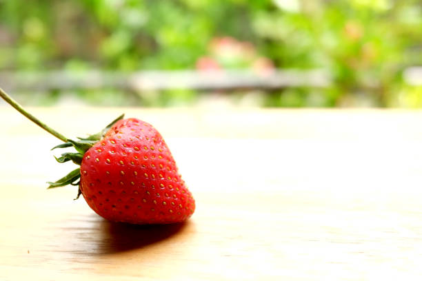 istock Fresh strawberry on wooden table in natural green background.Copy Space 1017070894