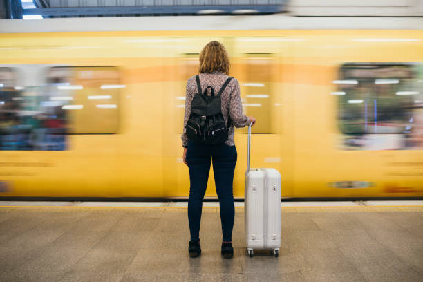 vista posteriore di una donna bionda in attesa alla banchina del treno - stazione della metropolitana foto e immagini stock