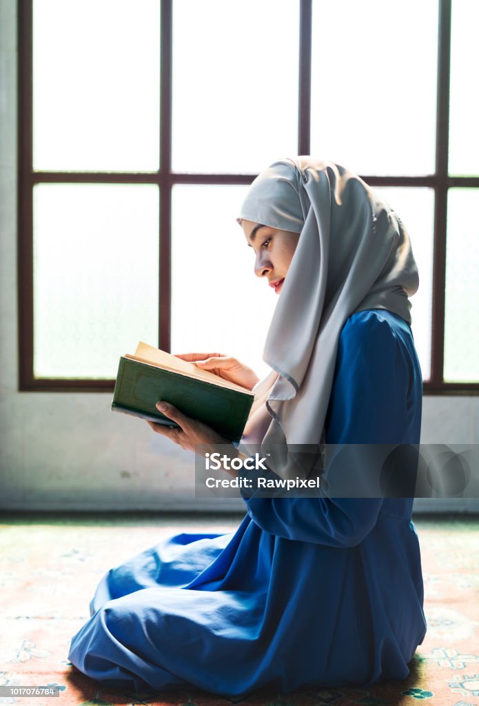 Muslim woman reading from the quran Islam Stock Photo