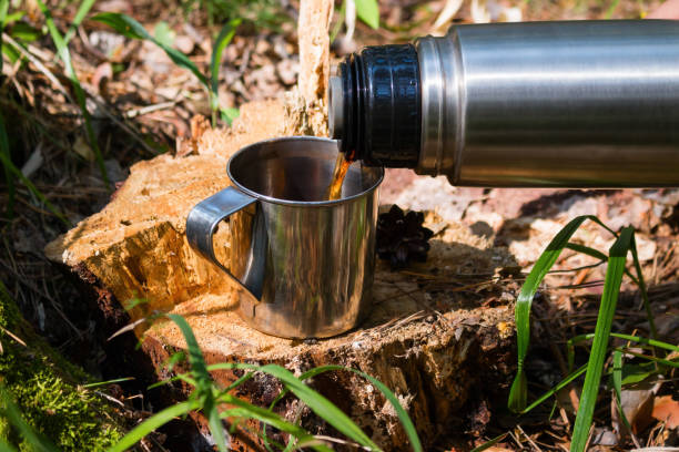 istock traveler in the forest pours tea from thermos 1017082998