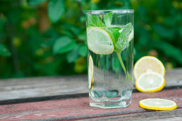 istock Water with lemon and mint in a transparent glass with facets. 1017097334