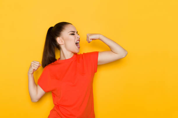 Young Woman Is Flexing Muscles And Shouting stock photo