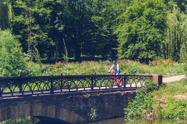 istock Cyclist in helmet riding in park on bridge 1017111104