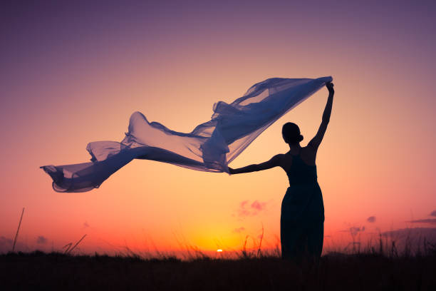 istock Women holding fabric blowing in the wind 1017117274