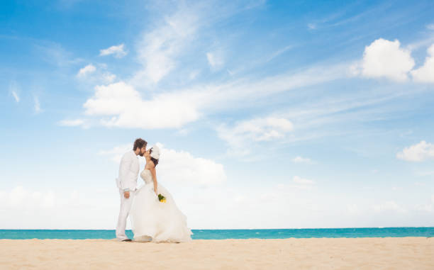coppia di nozze che si bacia sulla spiaggia. - wedding beach bride groom foto e immagini stock