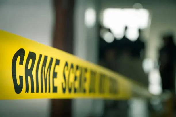 Photo of crime concept by police line tape with blurred forensic law enforcement background in cinematic tone