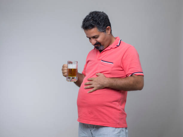 studio strzał z nadwagą człowieka z kieliszkiem piwa - pot belly greed overweight excess zdjęcia i obrazy z banku zdjęć