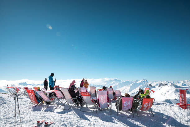 Bar With A View Val Thorens, France - February 21, 2018: Group of people relaxing in a restaurant terrace on Cime de Caron mountain in Val Thorens (3,195 metres above sea level) and enjoying the magnificent view. apres ski stock pictures, royalty-free photos & images