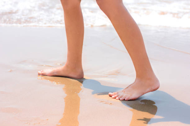 istock Bare feet walking at sandy beach near by sea 1017143624
