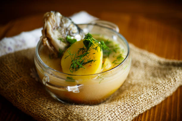 vegetable soup with fish in a glass bowl on a wooden table