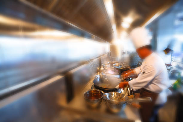 Cozinhando com o chef, cozinheiros de movimento de uma cozinha de restaurante - foto de acervo