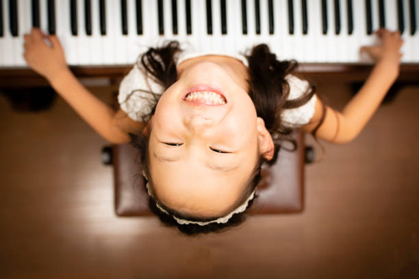 klavier spielen mädchen - practicing piano child playing stock-fotos und bilder