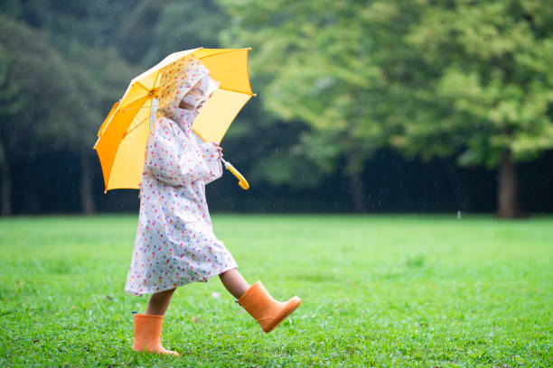 fille marche un jour de pluie - saison des pluies photos et images de collection