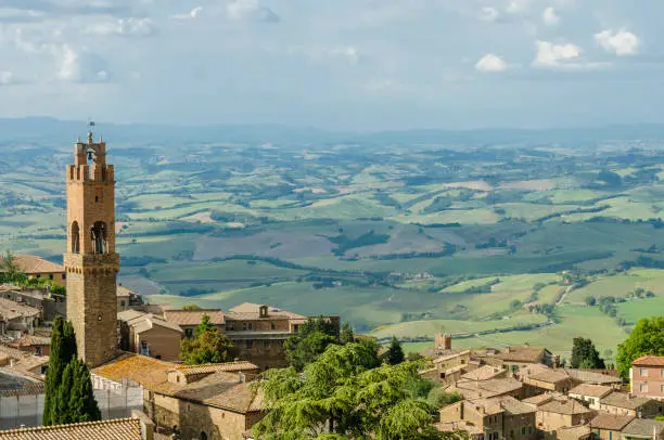 Rooftops of Montalcino and scenic view of typical Tuscany landscape in Val D'Orcia: hills, meadows and green fields. Tuscany, Italy, Europe