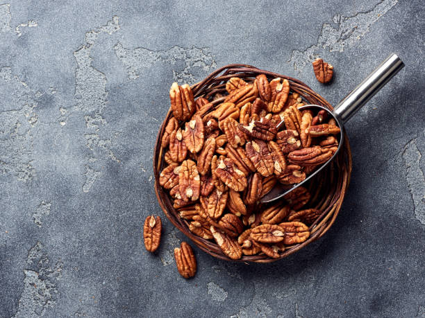 Pecan nuts and scoop on gray table stock photo
