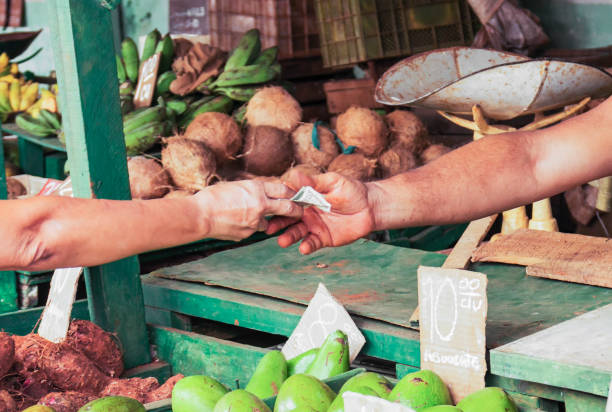 Money being exchanged at market in Old Havana Cuba Money changing hands for produce purchased at a market in Havana Cuba. cuba market stock pictures, royalty-free photos & images