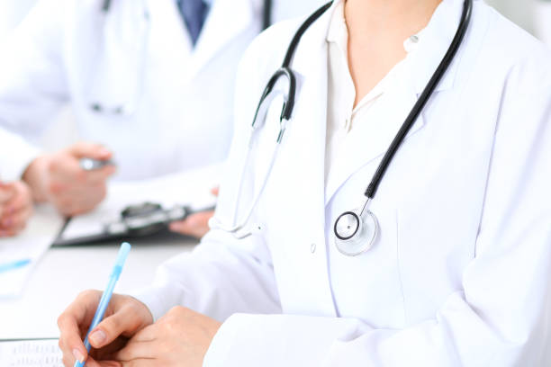 istock Group of unknown doctors working at hospital while sitting at the table. Teamwork and success concept in medicine. 1017175090