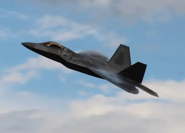 F22 Raptor performing a high speed pass with white vapor forming on wings and bright blue sky with white clouds in background