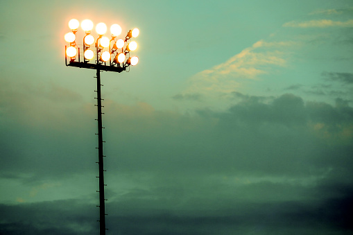 Sports stadium lights at dusk, night.  Dramatic sky.  Football, baseball, or soccer field.