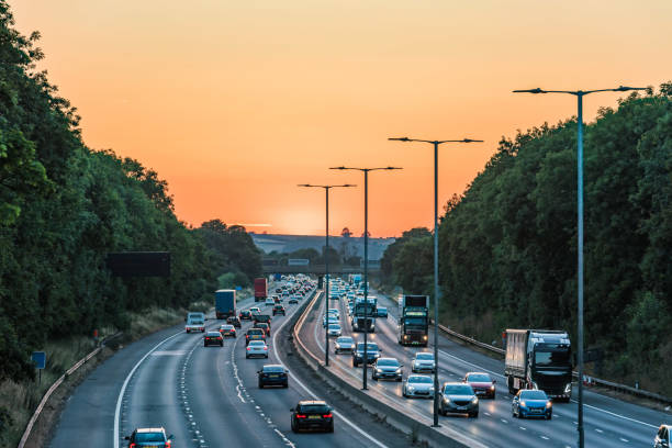 Sunset view of busy UK Motorway traffic in England Sunset view of busy UK Motorway traffic in England. multiple lane highway stock pictures, royalty-free photos & images