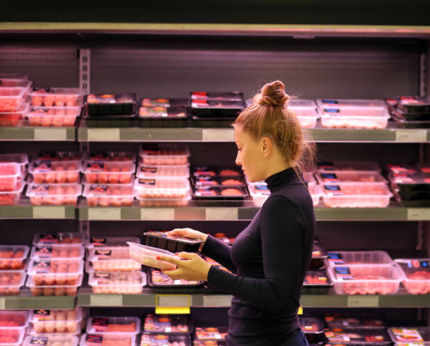 mujer compra un paquete de carne en el supermercado - supermarket meat women packaging fotografías e imágenes de stock