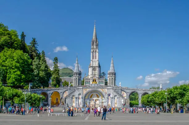 Lourdes, France, August 2013: The Basilica of Our Lady of Immaculate Conception of Lourdes  is built on the top of the rock above the Grotto